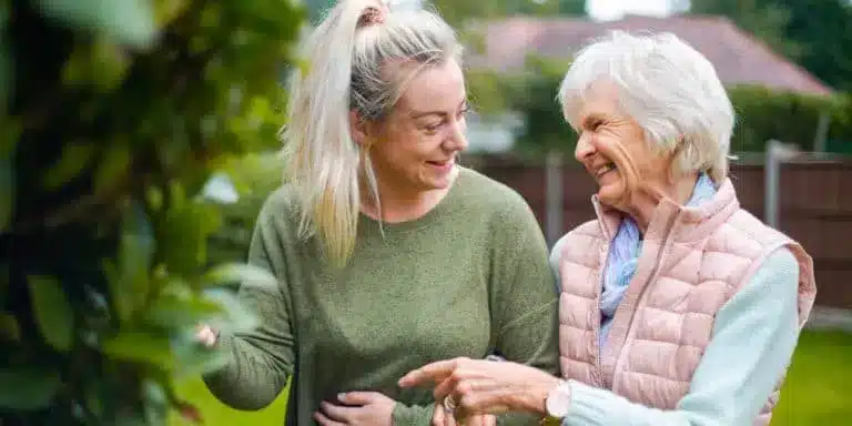 international carer helping elderly lady around the garden 2x1 768x384 1.webp